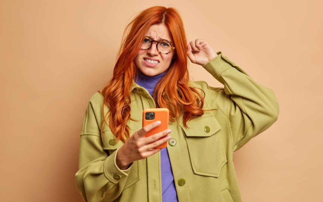 Woman experiencing anxiety holding mobile phone